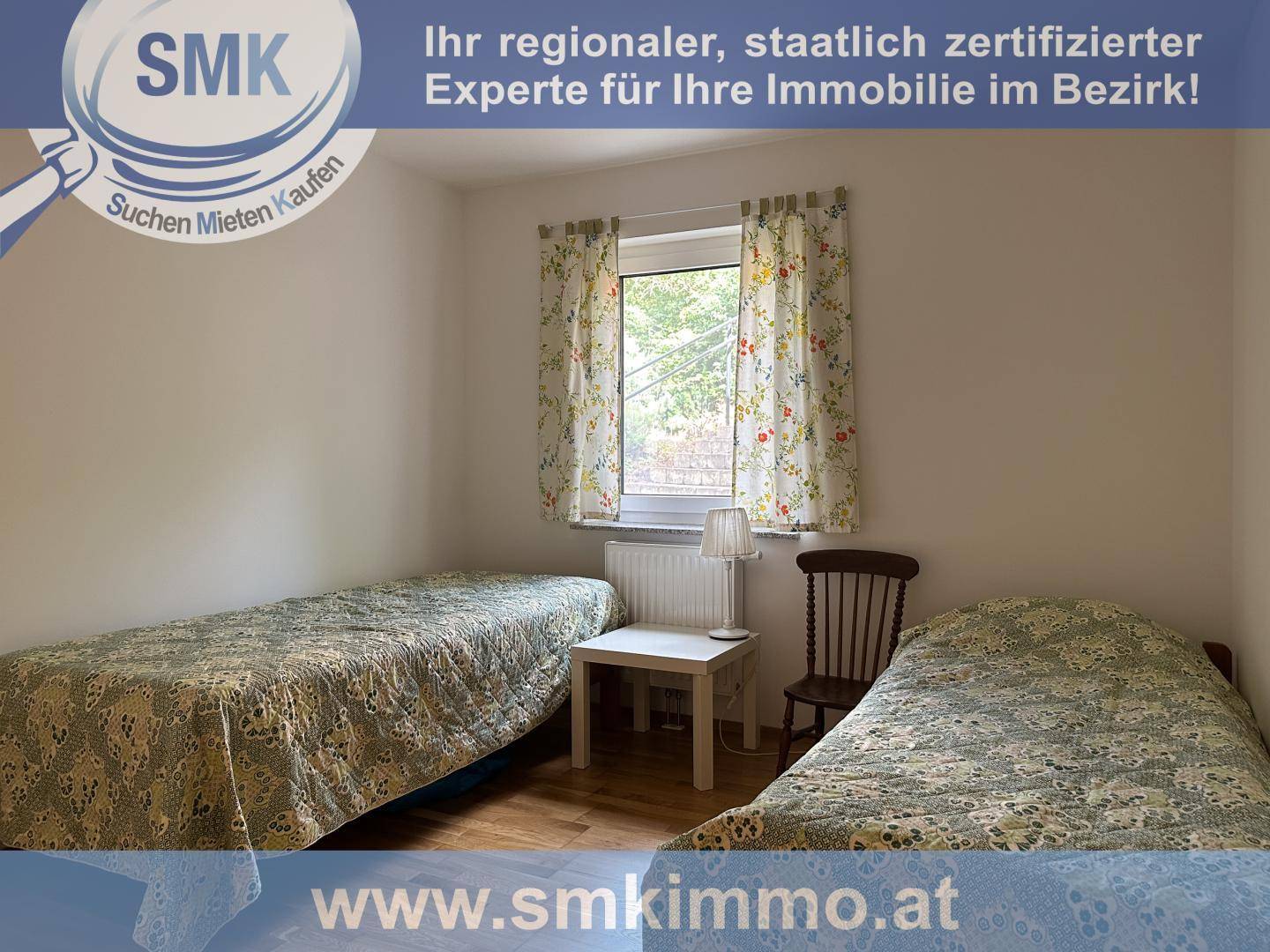 Schlafzimmer mit zwei Einzelbetten und einem Fenster, das Tageslicht spendet.