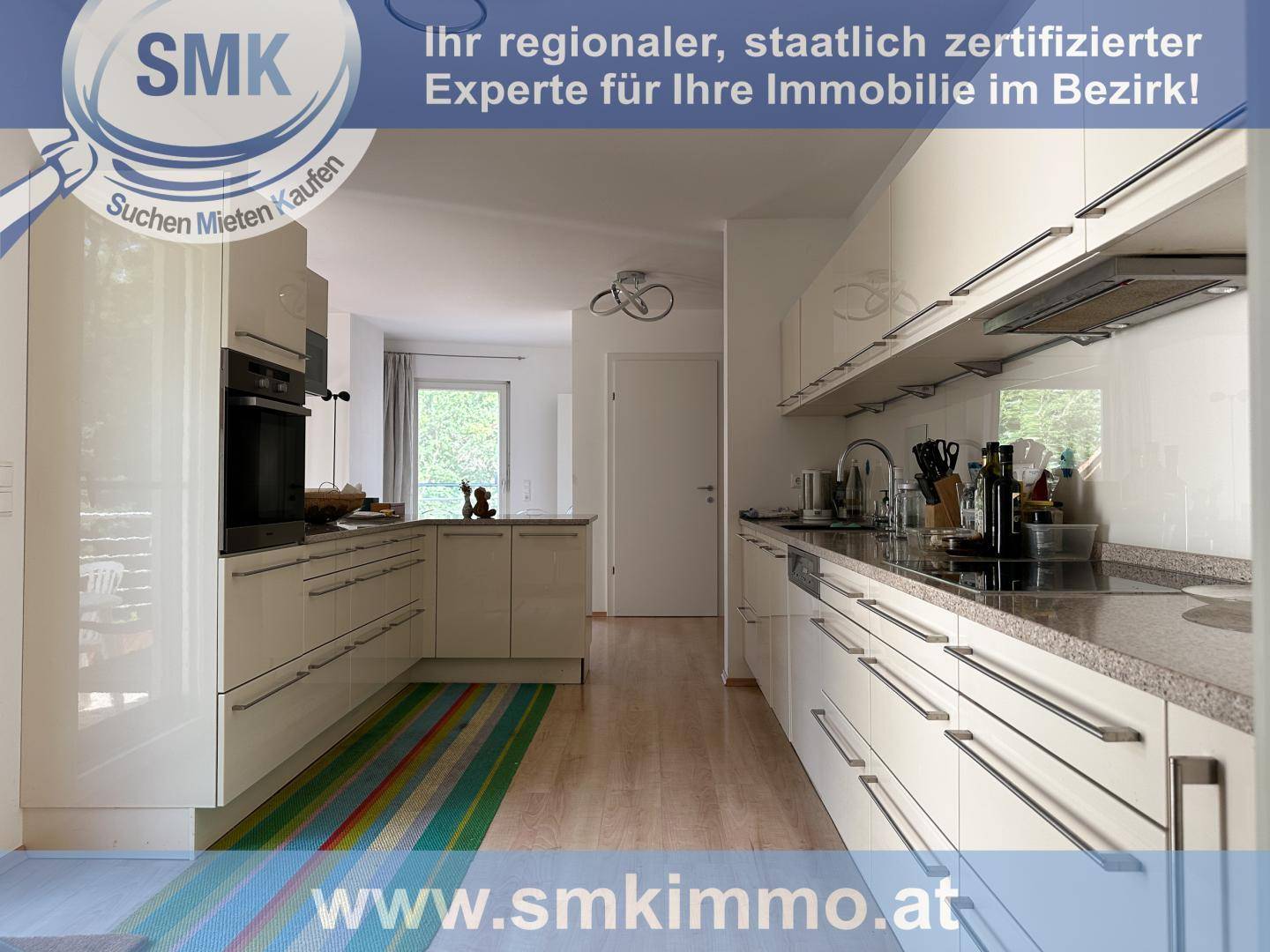 Moderne Küche mit weißen Schränken, Granitarbeitsplatte und Holzboden.