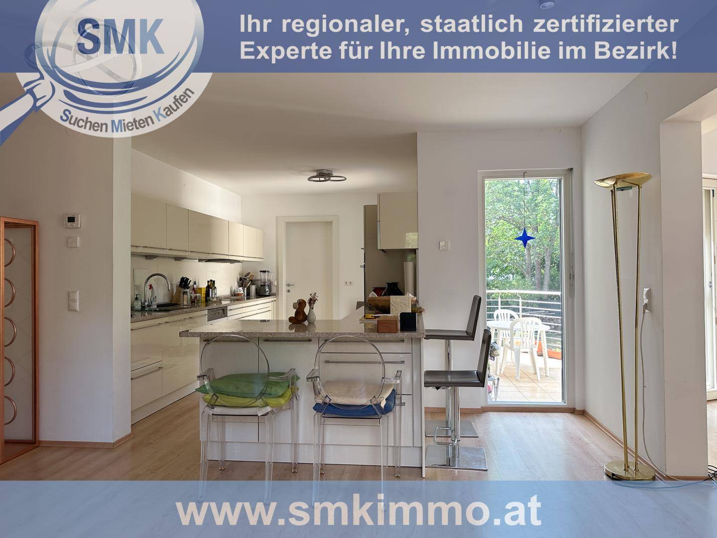 Helle Küche mit Kücheninsel und Zugang zu einem Balkon oder einer Terrasse.