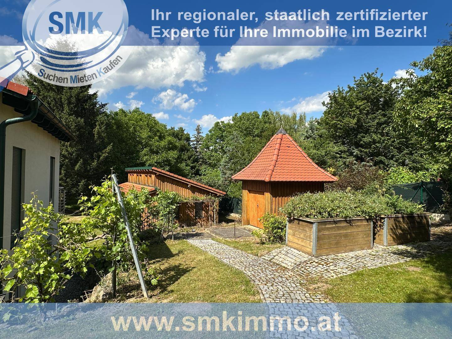 Gartenbereich mit Holzpavillon, Hochbeeten und gepflasterten Wegen.