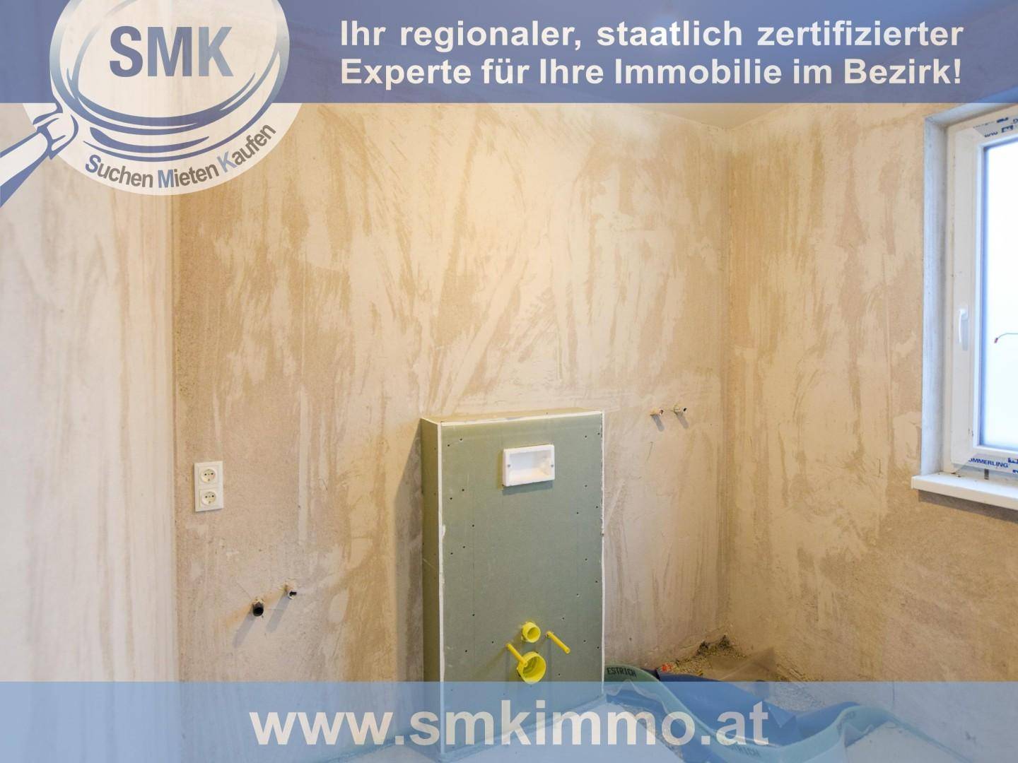Unfertiges Badezimmer mit vorbereiteten Anschlüssen für Toilette und Waschbecken, bereit für den Ausbau.
