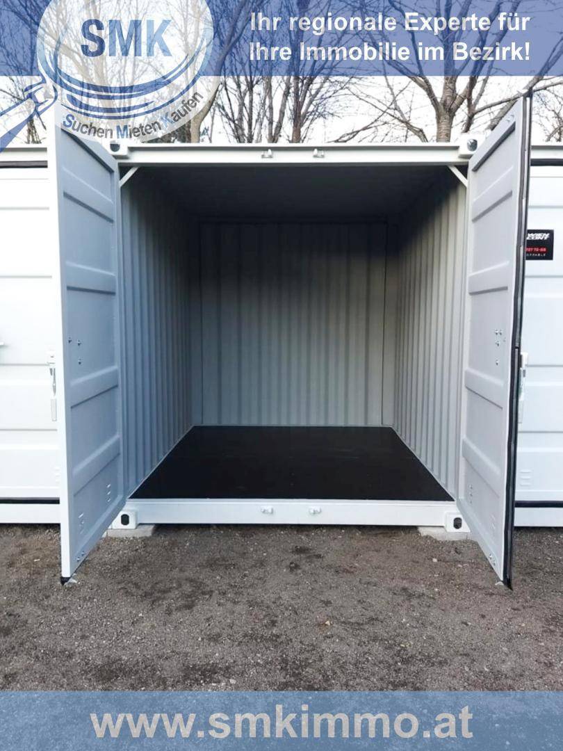 Innenansicht eines geöffneten weißen Lagercontainers mit schwarzem Boden und grauen Metallwänden.
