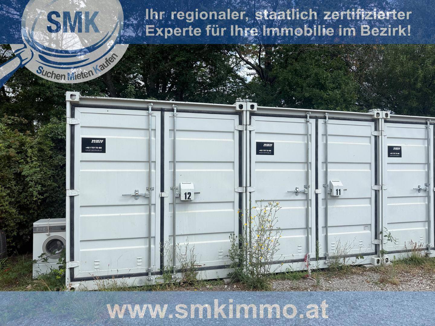Nahaufnahme von drei weißen Lagercontainern mit Nummern auf einem Schotterplatz und Unkraut.