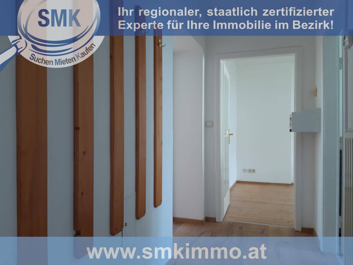 Heller Flur mit Holzboden und einer Garderobe, der zu einem weiteren Raum führt.