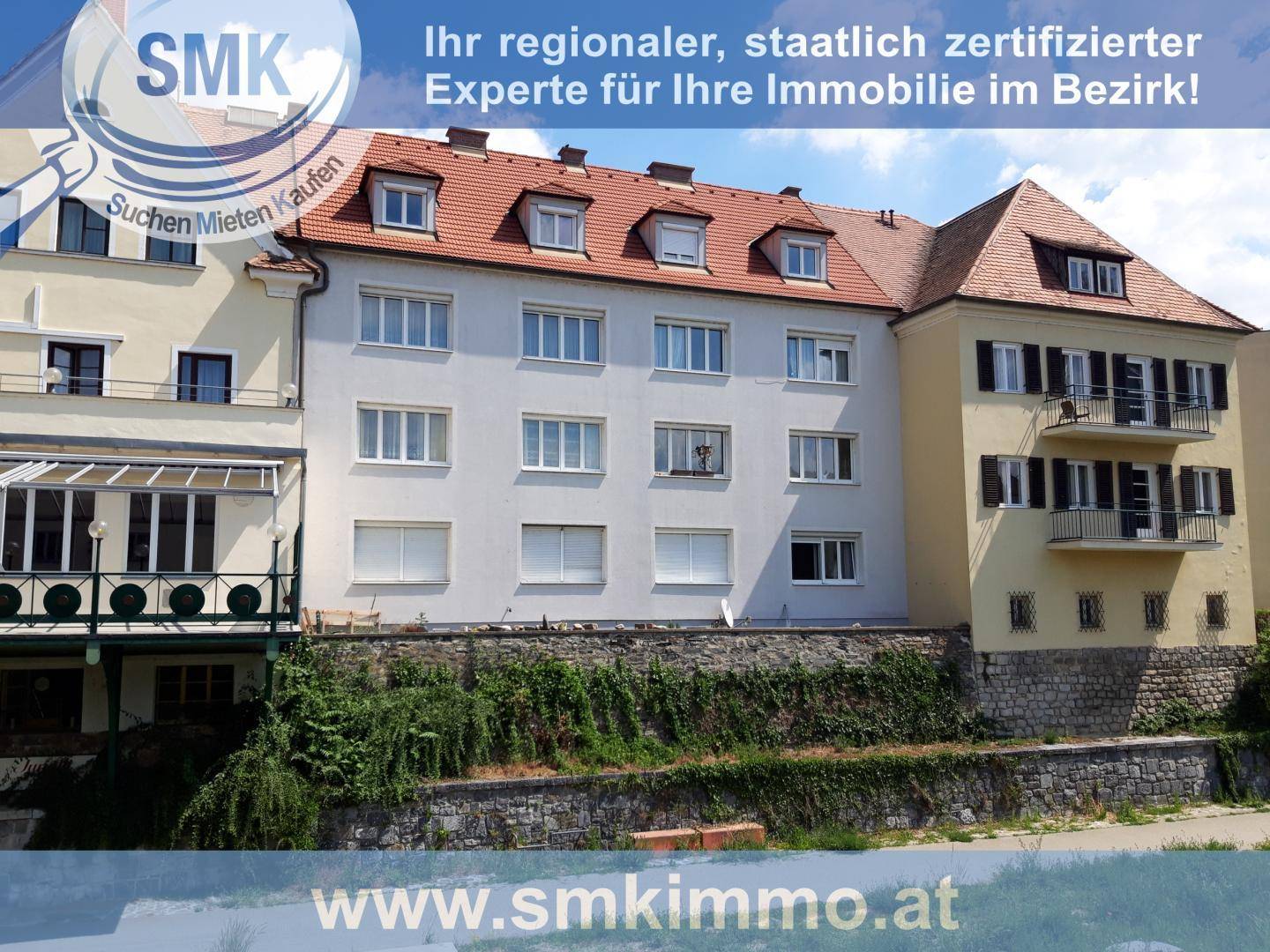 Mehrstöckiges Wohngebäude mit vielen Fenstern und Balkonen, charakterisiert durch ein Mansarddach.