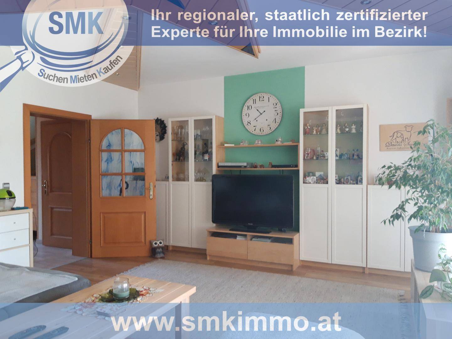 Helles Wohnzimmer mit TV-Möbeln, Vitrinen und einem grünen Akzentbereich an der Wand.