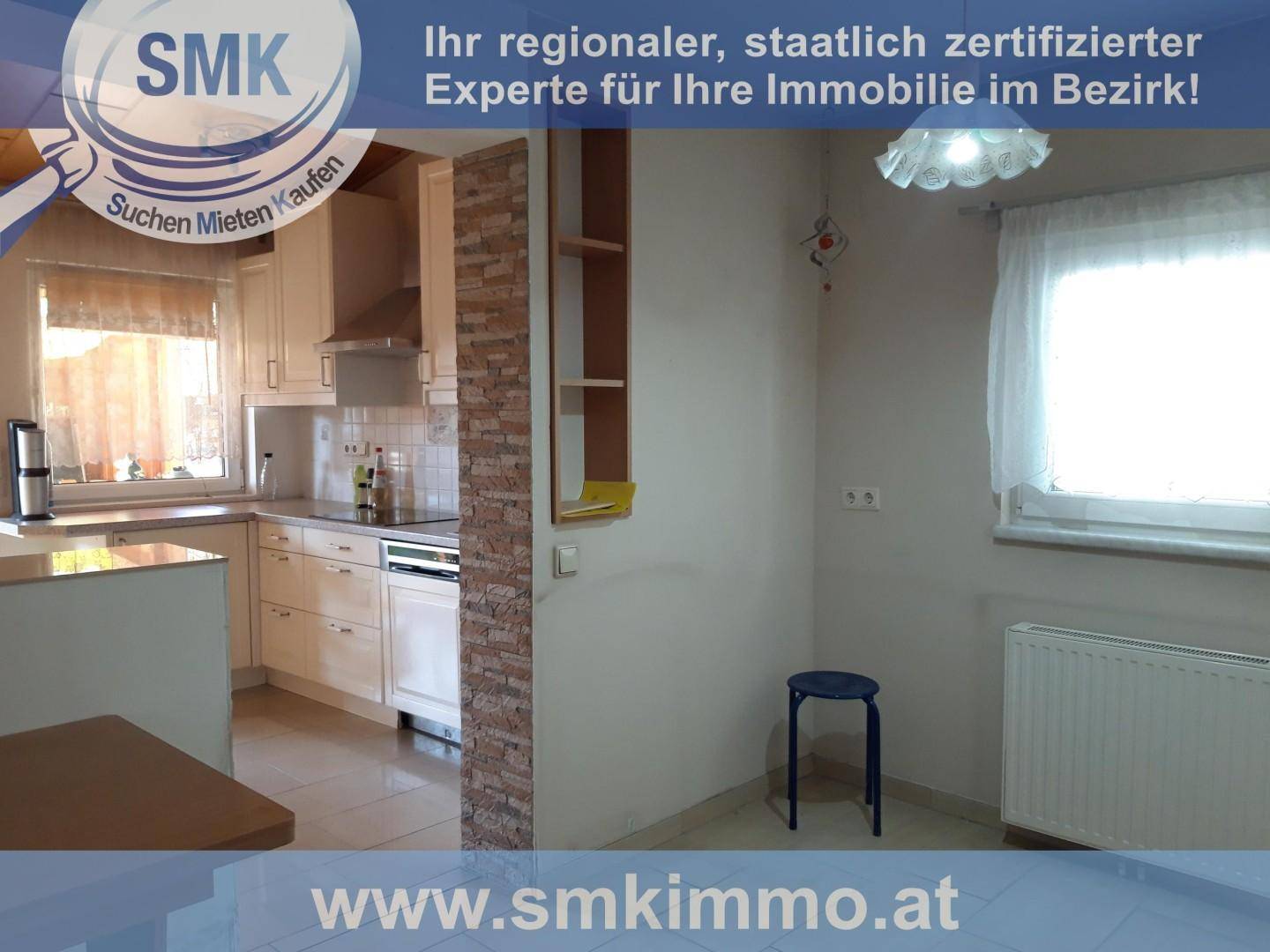 Helle Küche mit Einbauschränken, Fliesenboden und einem Fenster, das viel Licht hereinlässt.