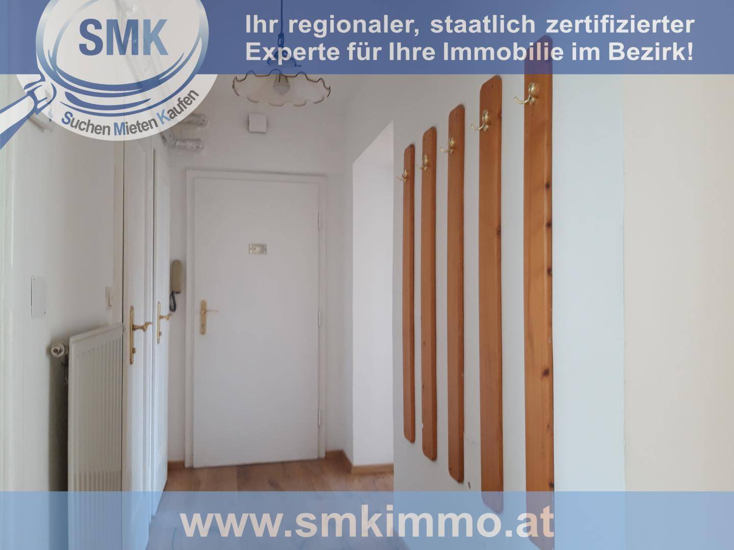 Schmaler Flur mit Holzboden, einer praktischen Garderobe und einem Heizkörper an der Wand.