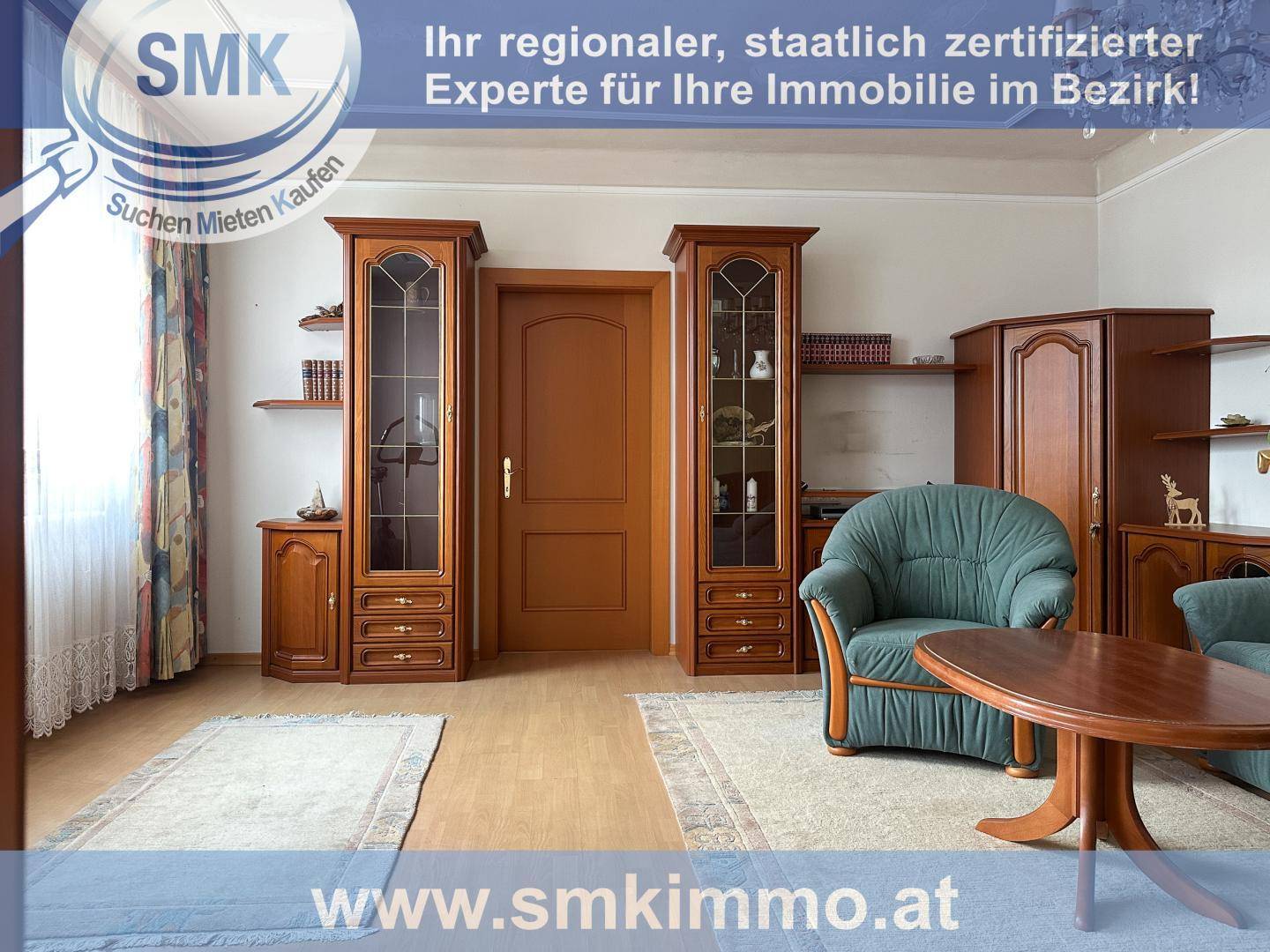 Gemütliches Wohnzimmer mit traditionellen Holzmöbeln und grünem Sessel.