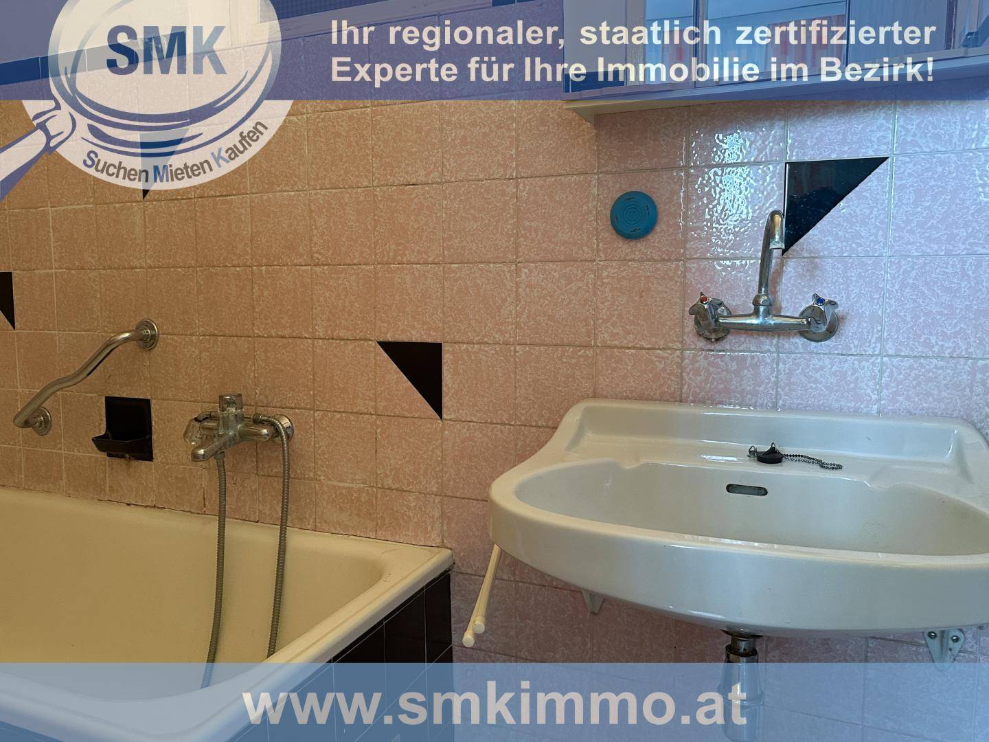 Badezimmer mit Badewanne, Waschbecken und rosa Wandfliesen.