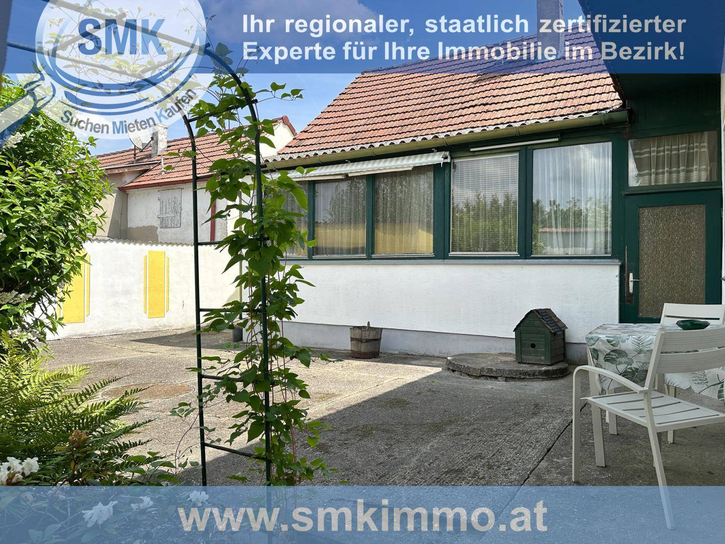 Terrasse mit Gartenmöbeln und Blick auf das Haus und die Umgebung.