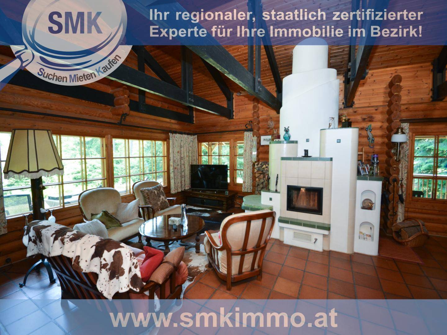 Gemütliches Wohnzimmer mit großem Kachelofen, Holzbalken und rustikalen Möbeln.