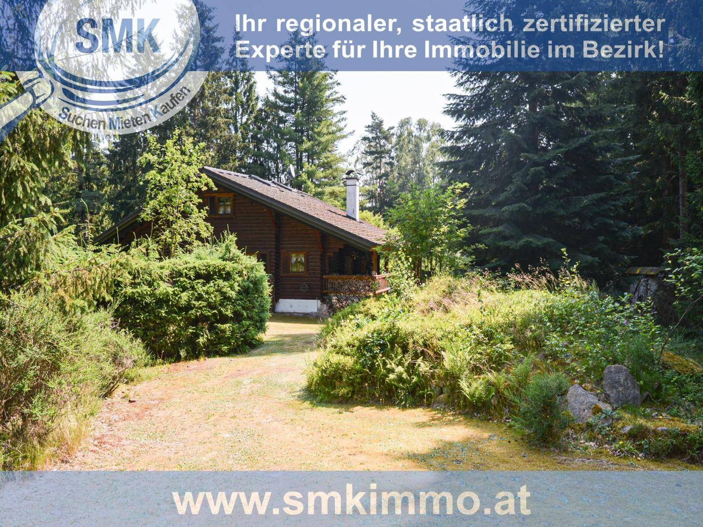 Charmante Blockhütte umgeben von dichtem Wald und grüner Naturlandschaft.