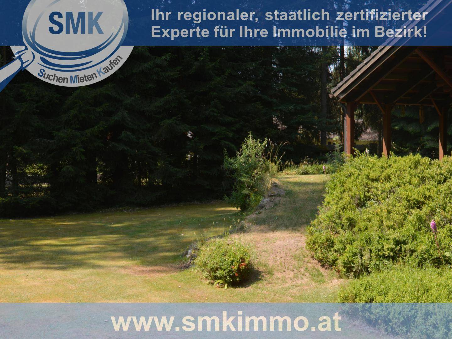 Weitläufiger Gartenbereich mit Rasen und üppigen Büschen in natürlicher Umgebung.