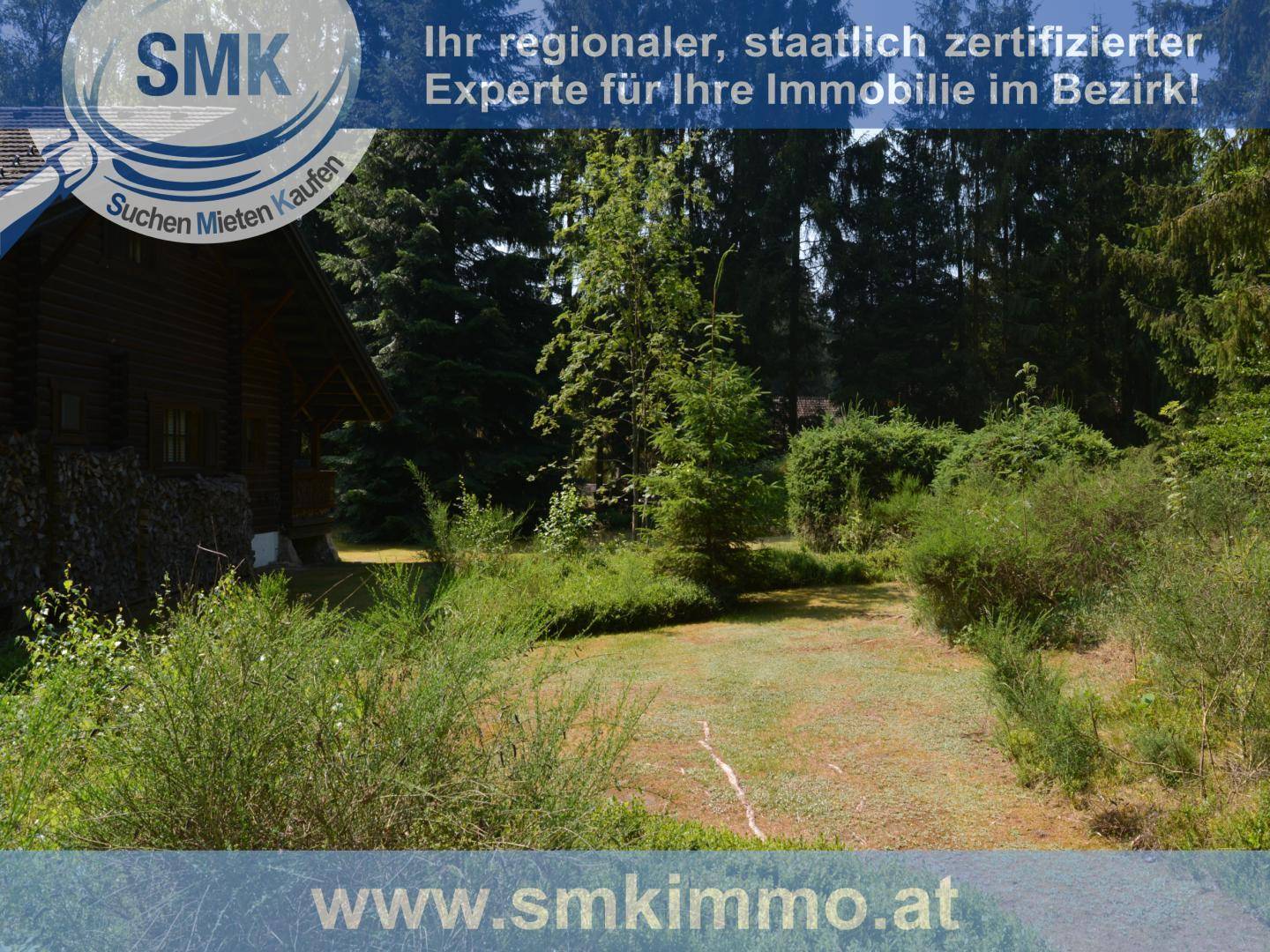 Grüner Gartenweg führt durch die Landschaft zur Blockhütte, umgeben von Natur.