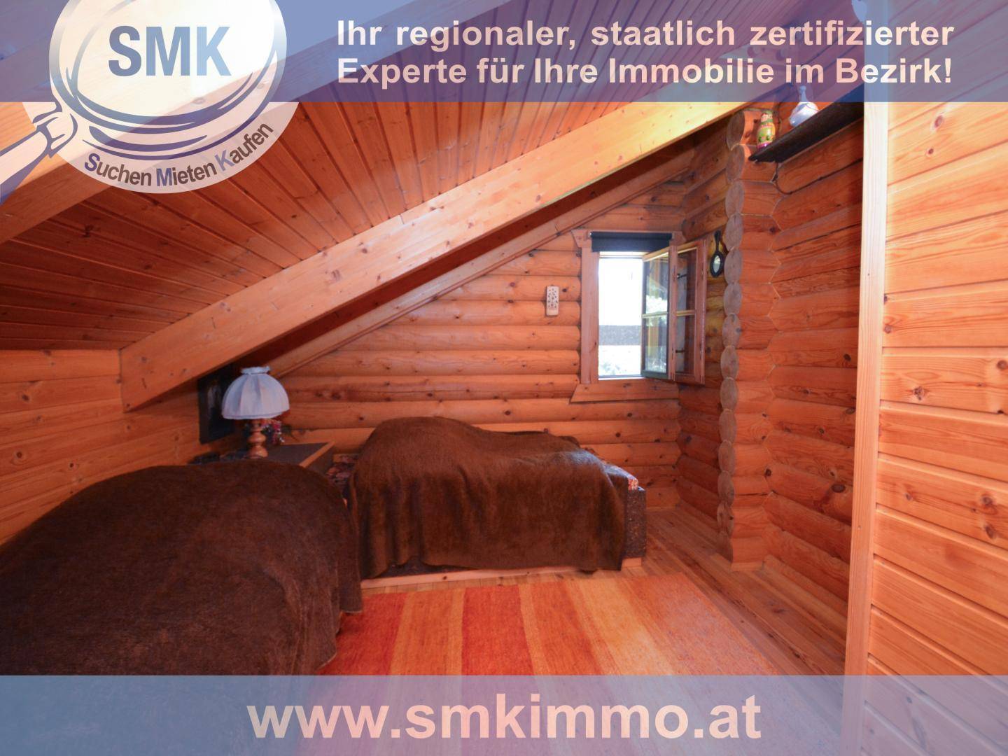 Gemütliches Schlafzimmer im Dachgeschoss mit Holzwänden und schrägen Decken.