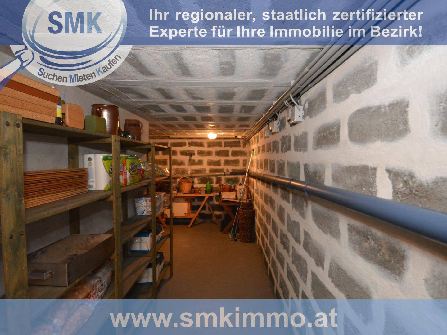 Langer Kellerraum mit Holzregalen und unverputzten Betonsteinwänden, ideal als Stauraum.