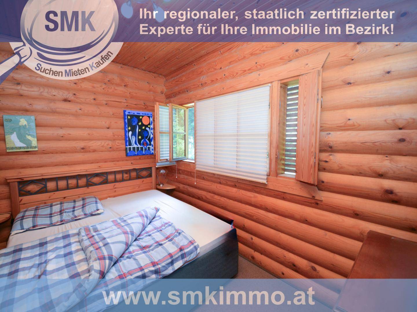 Schlafzimmer mit Holzwänden, Doppelbett und Fenstern für viel Tageslicht.
