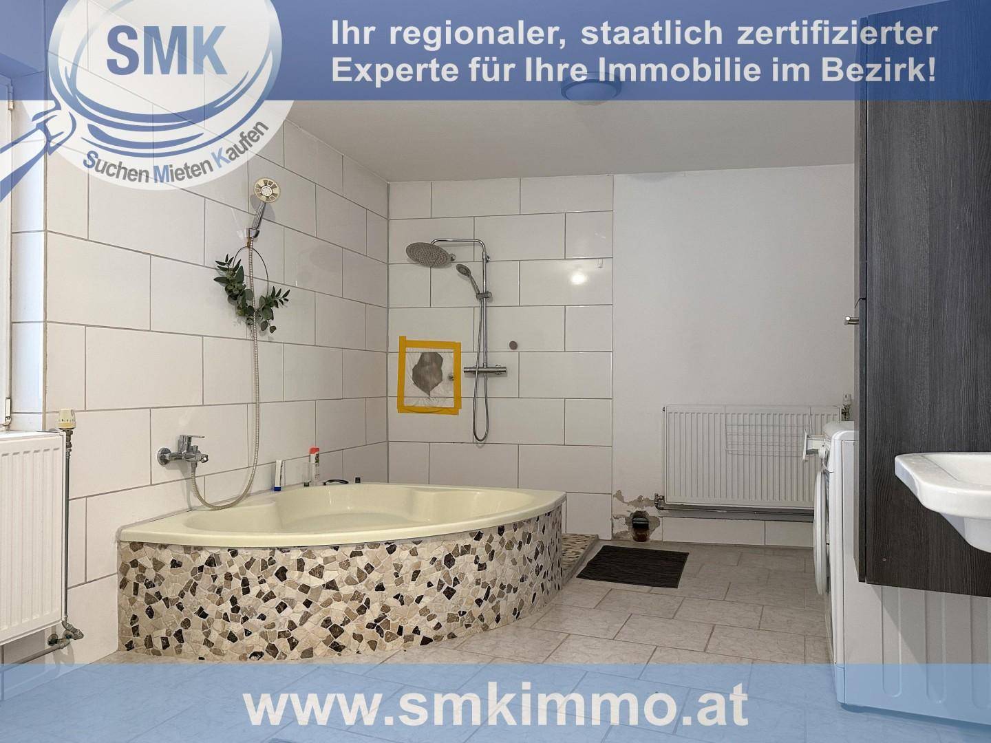 Badezimmer mit Eckbadewanne, Dusche, weißen Fliesen und Waschbecken.