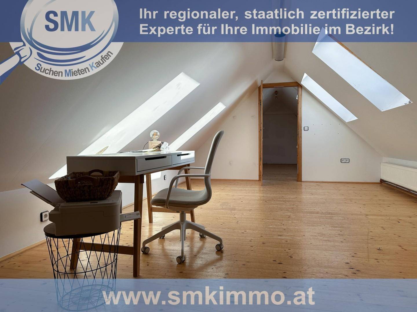 Helles Arbeitszimmer im Dachgeschoss mit Holzboden, Dachschrägen und Dachfenstern.