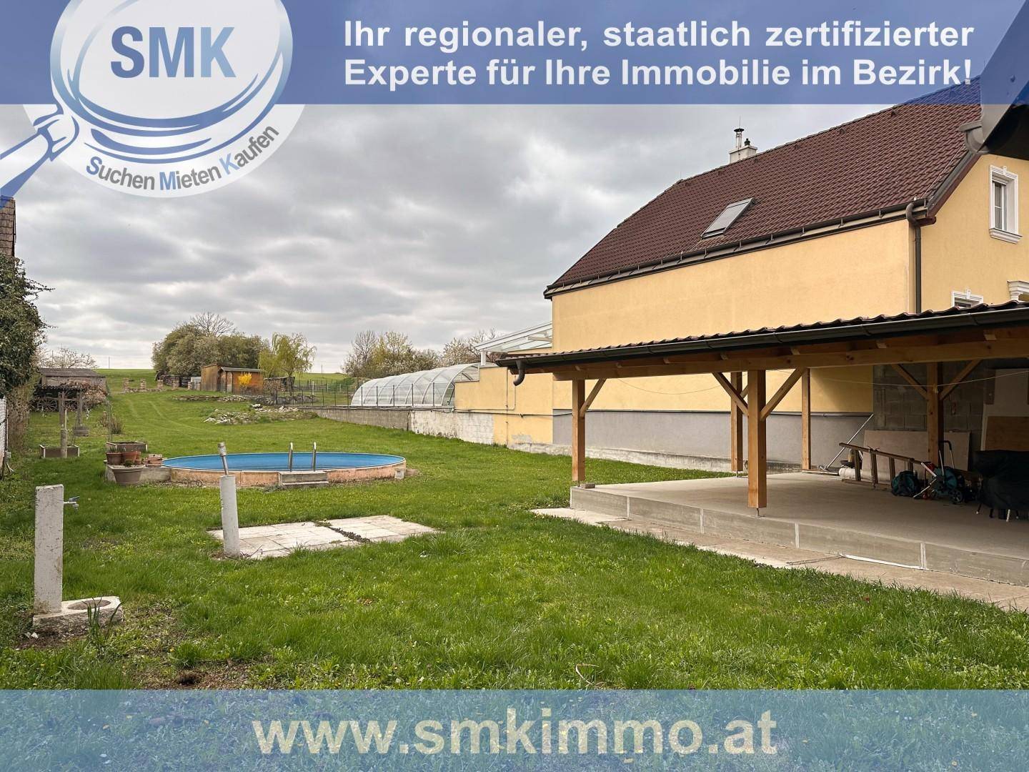 Hinterhof mit überdachter Terrasse, kleinem Pool und weitläufiger Rasenfläche.