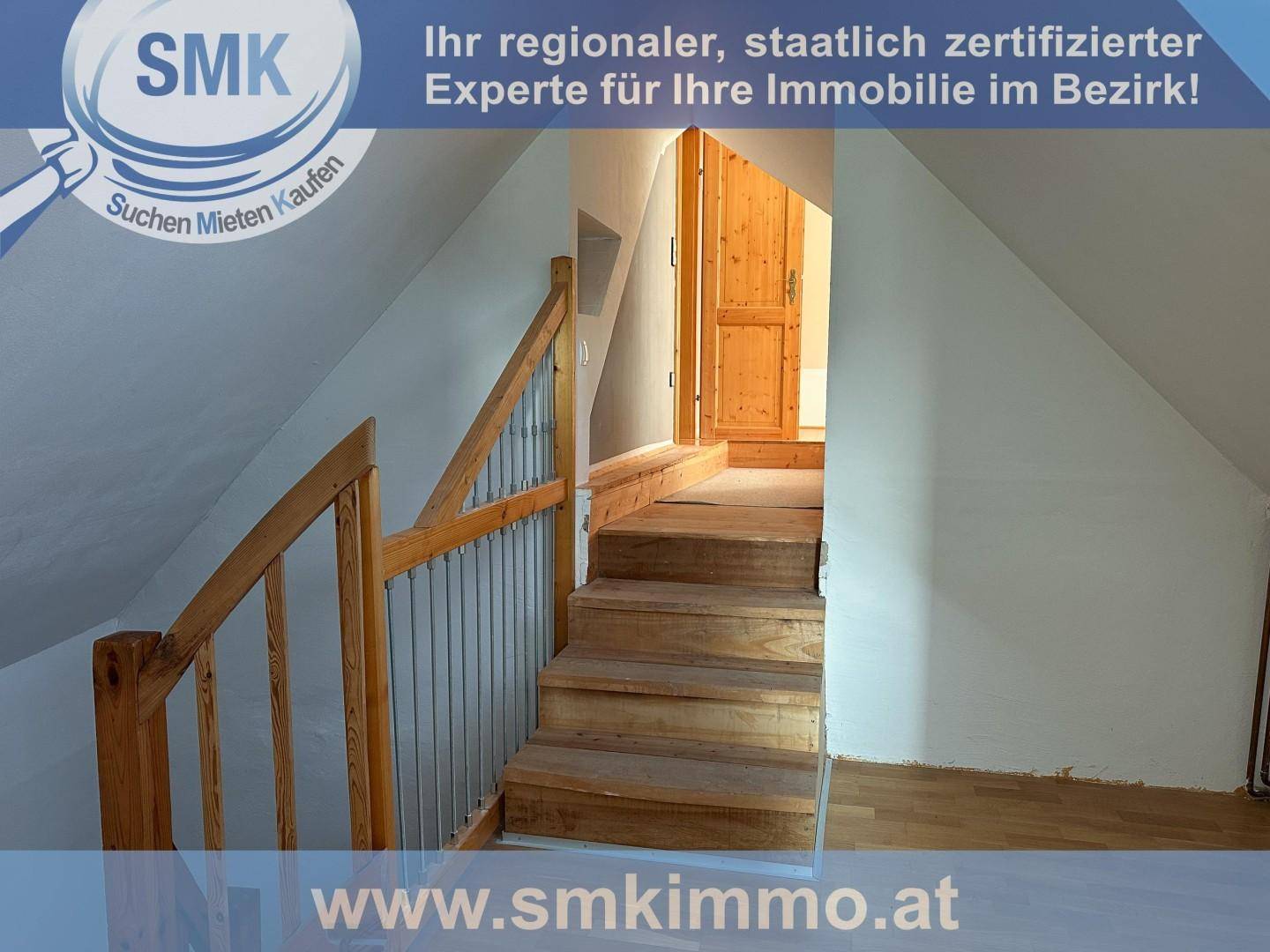 Holztreppe führt in den oberen Bereich des Dachgeschosses mit Holztüren.