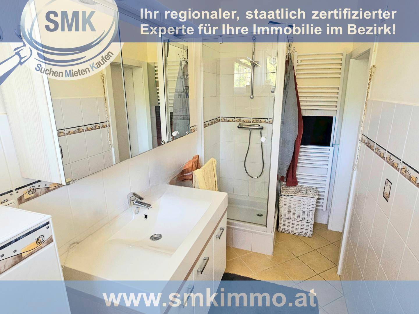 Gefliestes Badezimmer mit Dusche, Waschbecken und beheiztem Handtuchhalter.