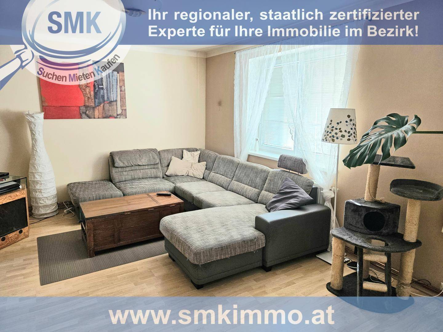 Gemütliches Wohnzimmer mit großem Ecksofa, Couchtisch und Fenster mit Vorhängen.