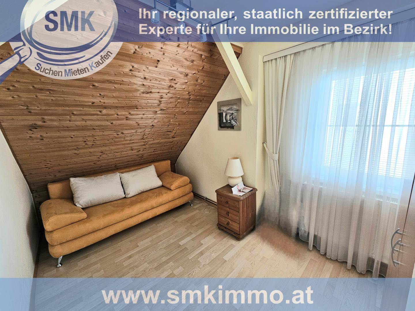Helles Zimmer im Dachgeschoss mit Schlafcouch, Holzboden und schrägen Wänden.