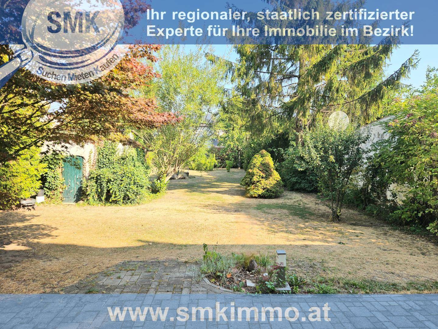 Großer, gepflegter Garten mit Rasenfläche und verschiedenen Bäumen und Sträuchern.