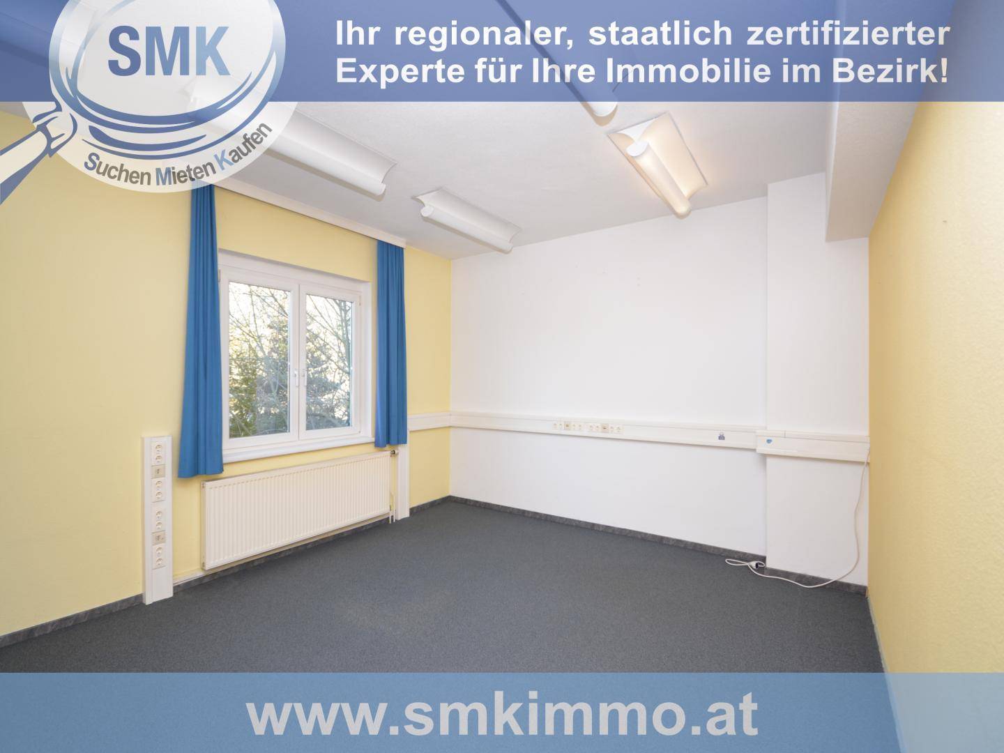 Leerer Büroraum mit gelben Wänden, blauen Vorhängen und dunklem Teppichboden, mit Fenster.