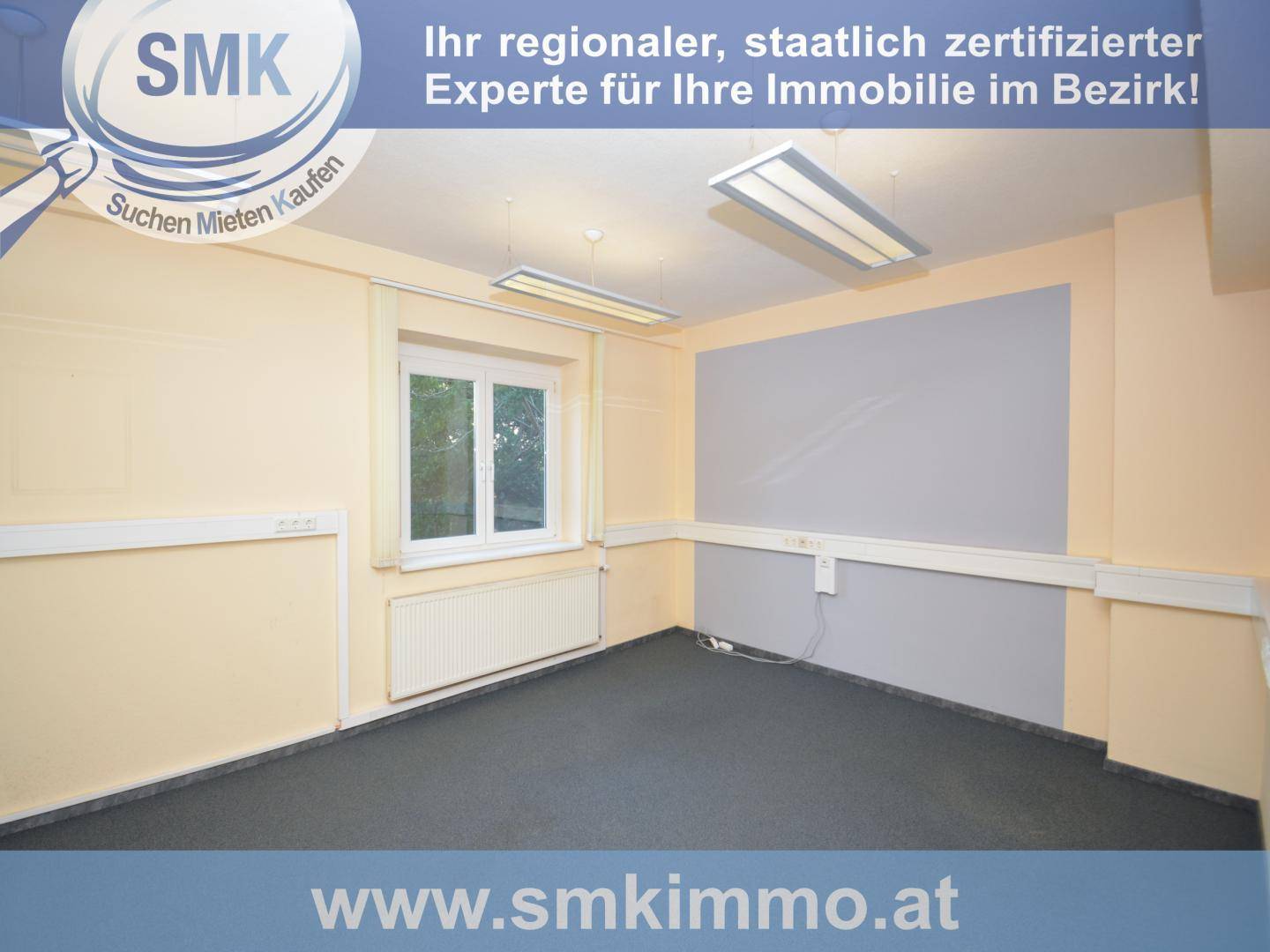 Leerer Büroraum mit gelben Wänden, grauem Akzent und dunklem Teppichboden, mit Fenster.