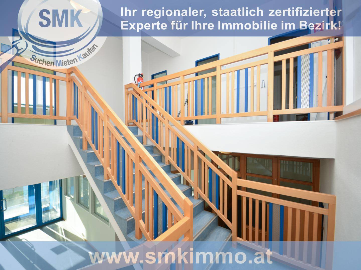 Mehrstöckiges Treppenhaus mit Holzgeländern und blauen Akzenten, hell und offen gestaltet.