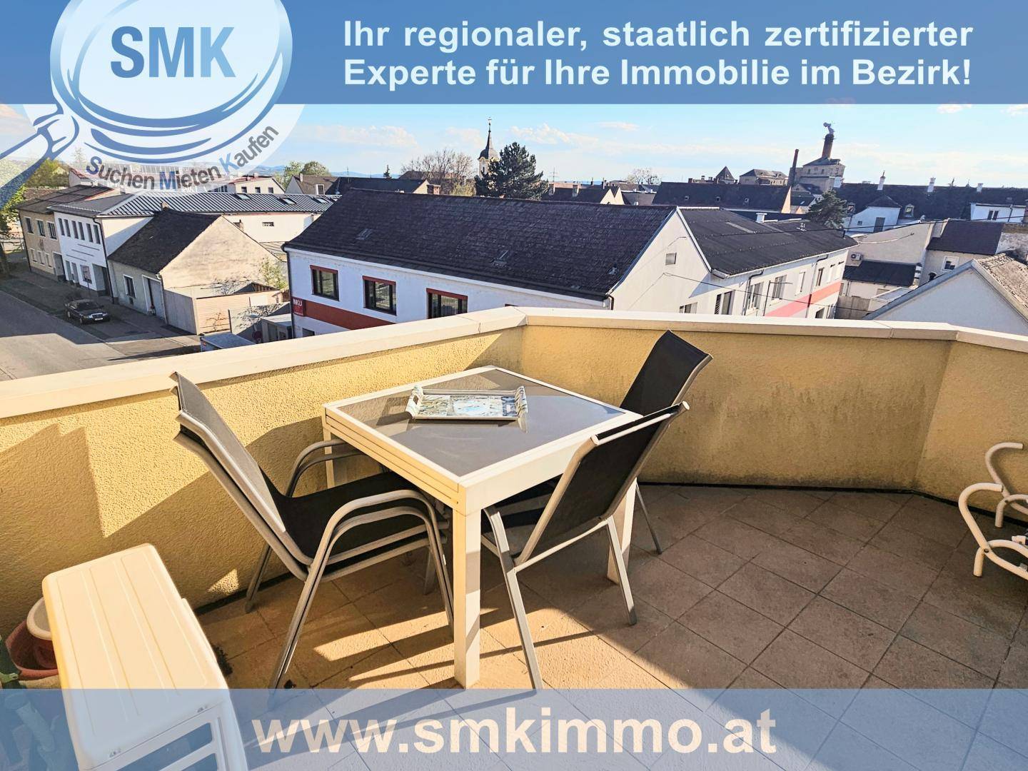 Möblierter Balkon mit Tisch und Stühlen bietet einen weiten Blick über die Dächer der Stadt.