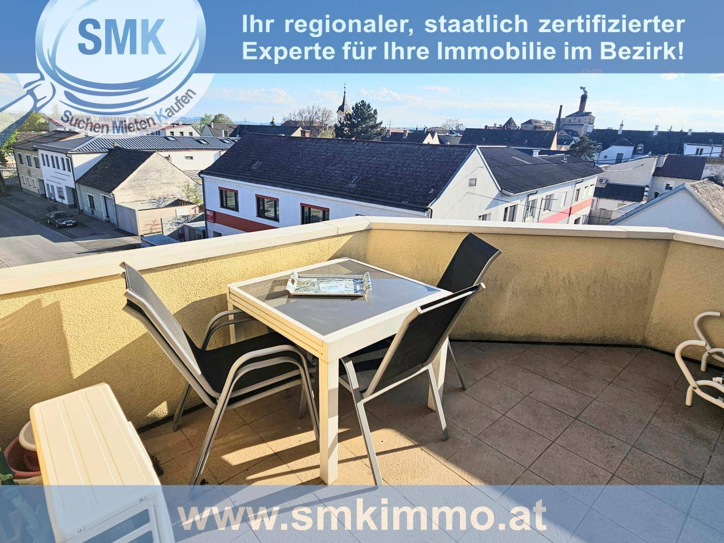 Möblierter Balkon mit Tisch und Stühlen bietet einen weiten Blick über die Dächer der Stadt.