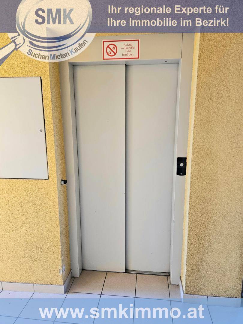 Aufzugstür in einem Flur eines Mehrfamilienhauses, bereit zur Nutzung.