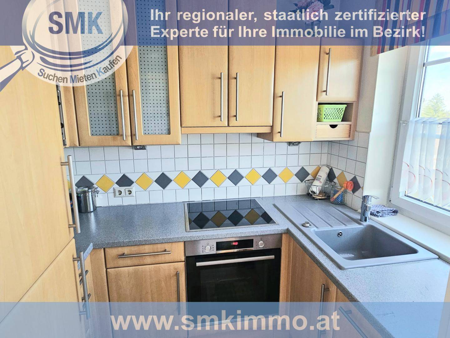Funktionale Küche mit Holzschränken, Induktionskochfeld, Backofen und dekorativen Fliesen.