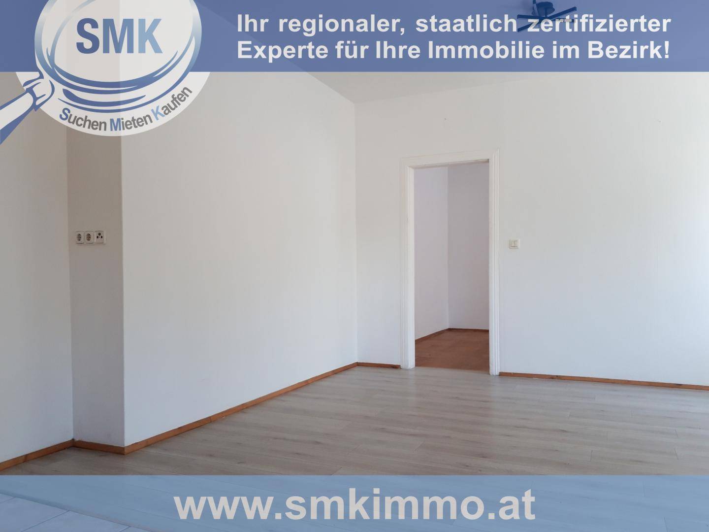 Leerer Raum mit weißen Wänden und modernem Laminatboden, bereit zur individuellen Gestaltung.