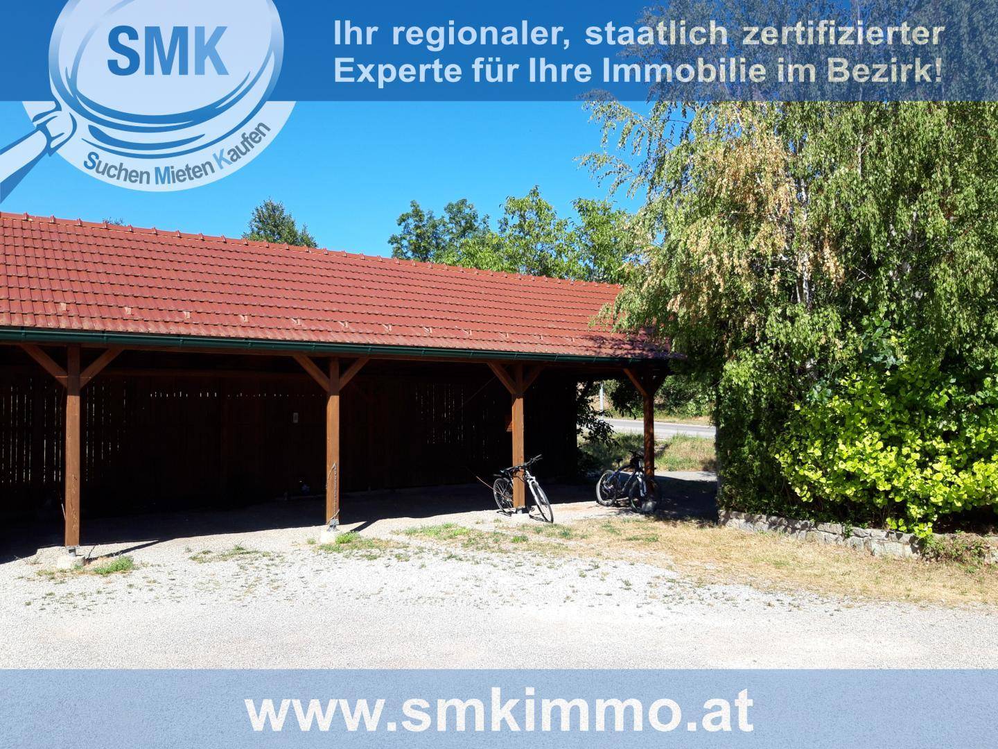Holzcarport mit Ziegeldach und Fahrrädern davor, ideal für zusätzlichen Stauraum.