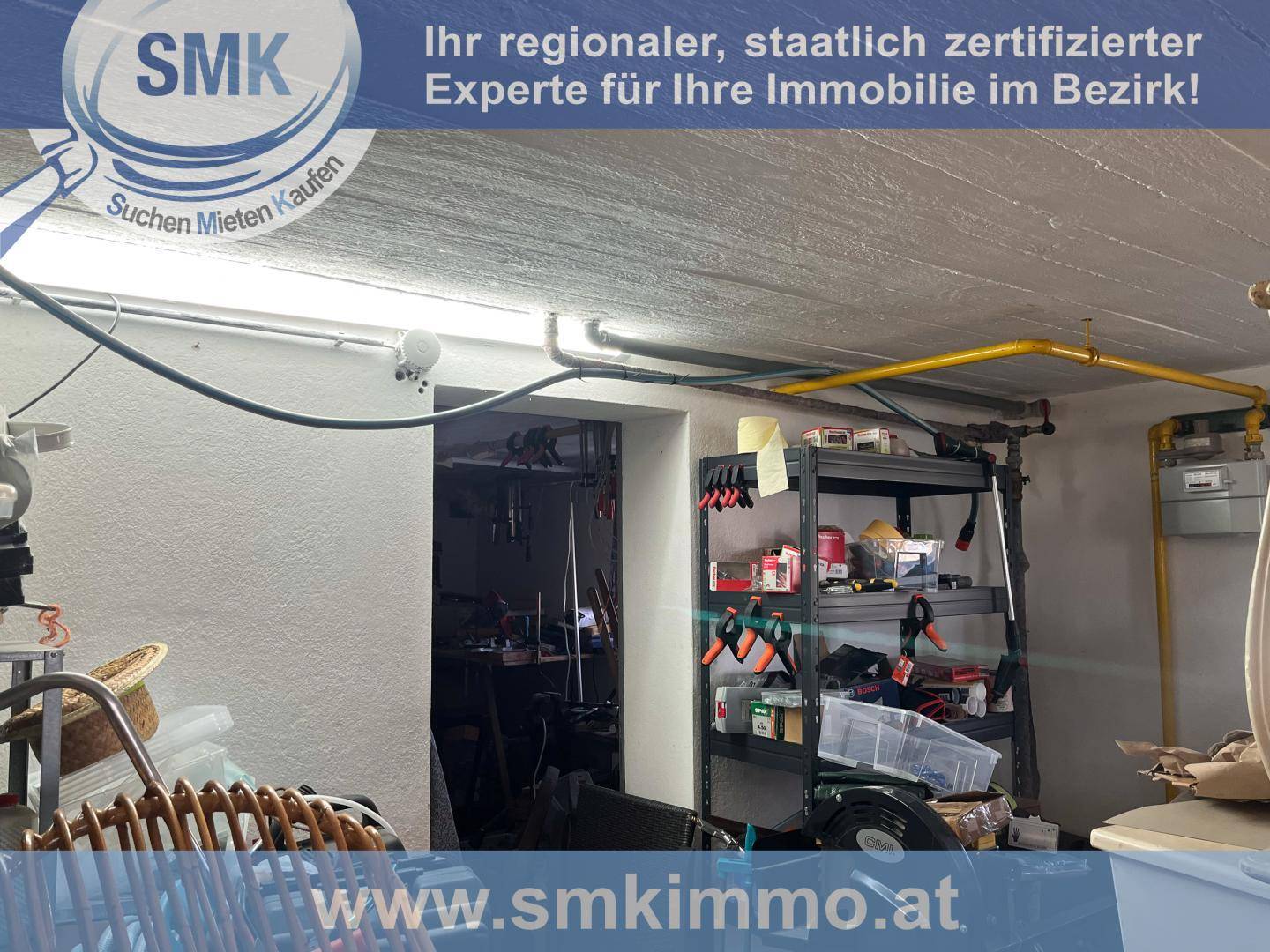 Funktionaler Kellerraum mit Regalen für Lagerung und sichtbaren Installationen an der Decke.