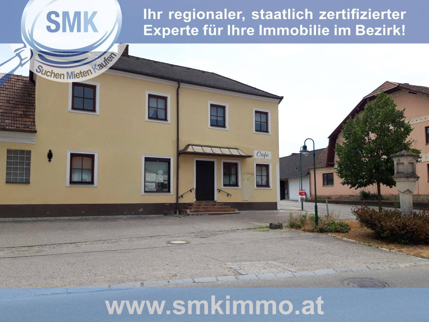 Gebäudefassade eines Hauses mit Café im Erdgeschoss und traditioneller Architektur.
