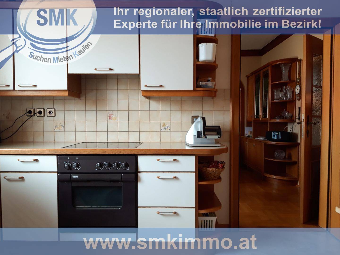 Funktionale Küche mit weißen Schränken, schwarzem Backofen und gefliestem Spritzschutz.