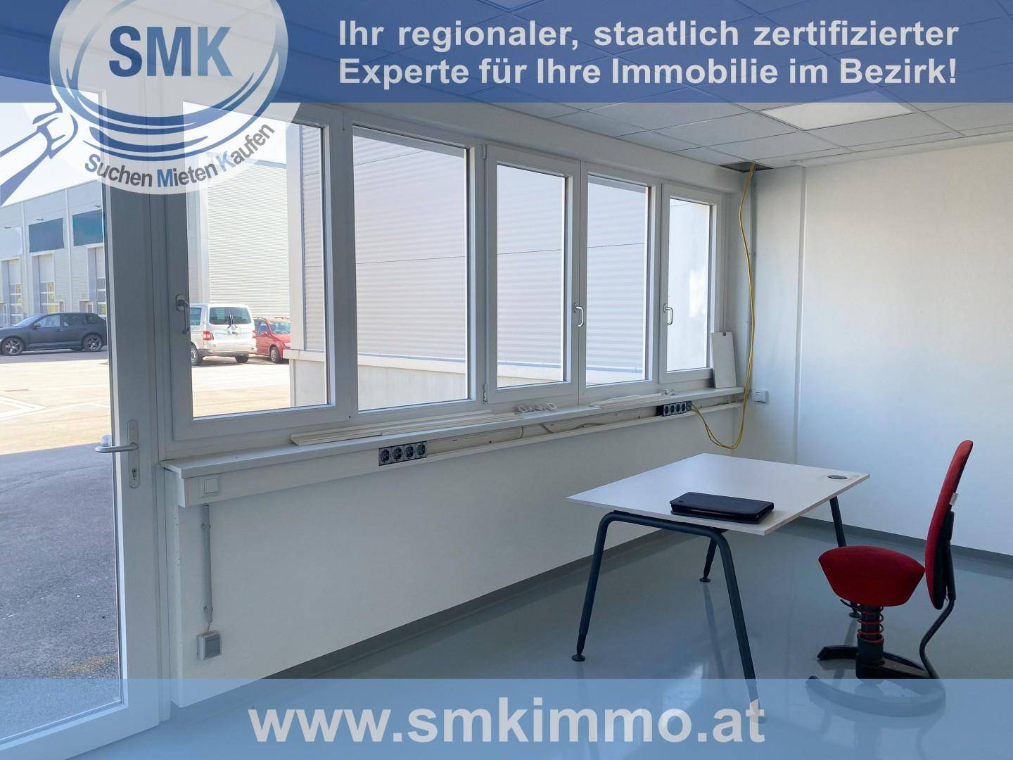 Helles Büro mit großen Fenstern, die viel Tageslicht hereinlassen, und Blick auf den Außenbereich des Gewerbeparks.