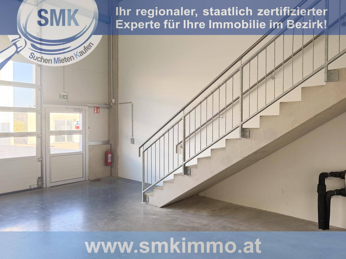 Geräumiger Innenbereich einer Gewerbehalle mit Betonboden und einer robusten Metalltreppe.