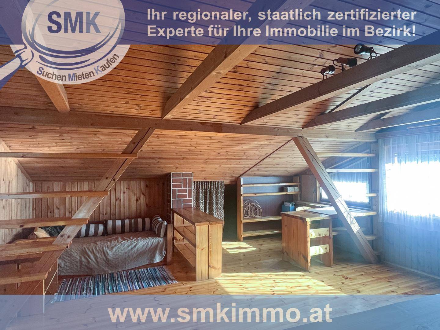 Ausgebauter Dachboden mit Holzvertäfelung, sichtbaren Balken und Schlafgelegenheit.