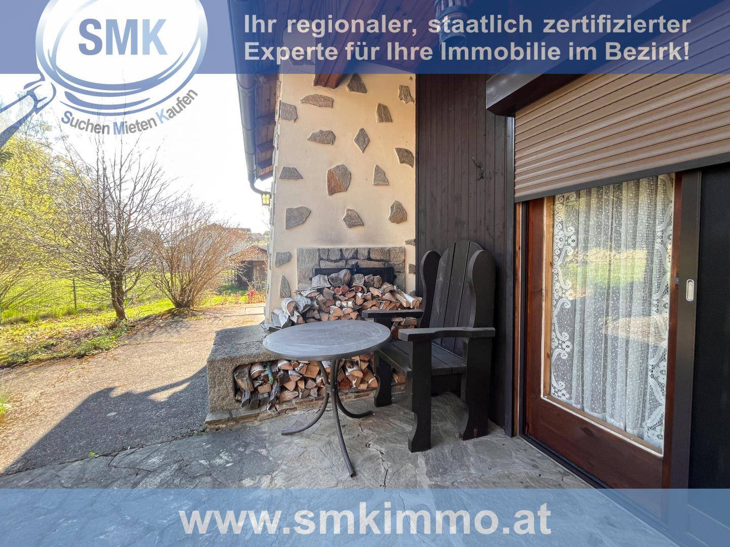 Gemütlicher Außenbereich mit Sitzgelegenheit und rustikalem Kamin für Holz.