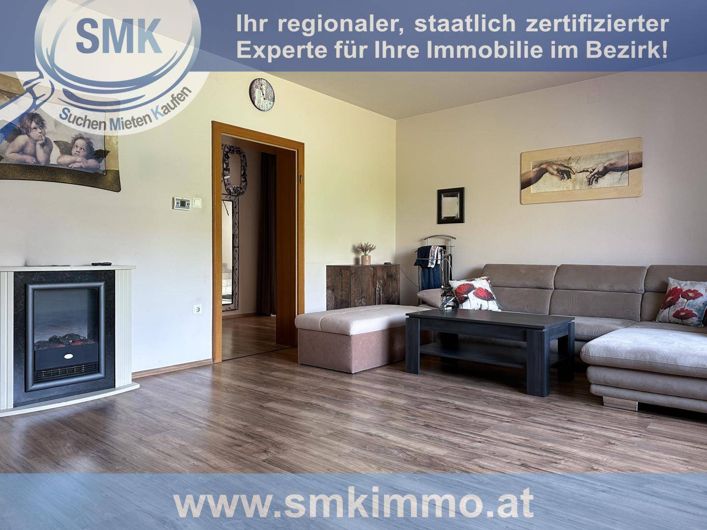 Wohnzimmer mit modernem Laminatboden, bequemer Couch und dekorativem Kamin.