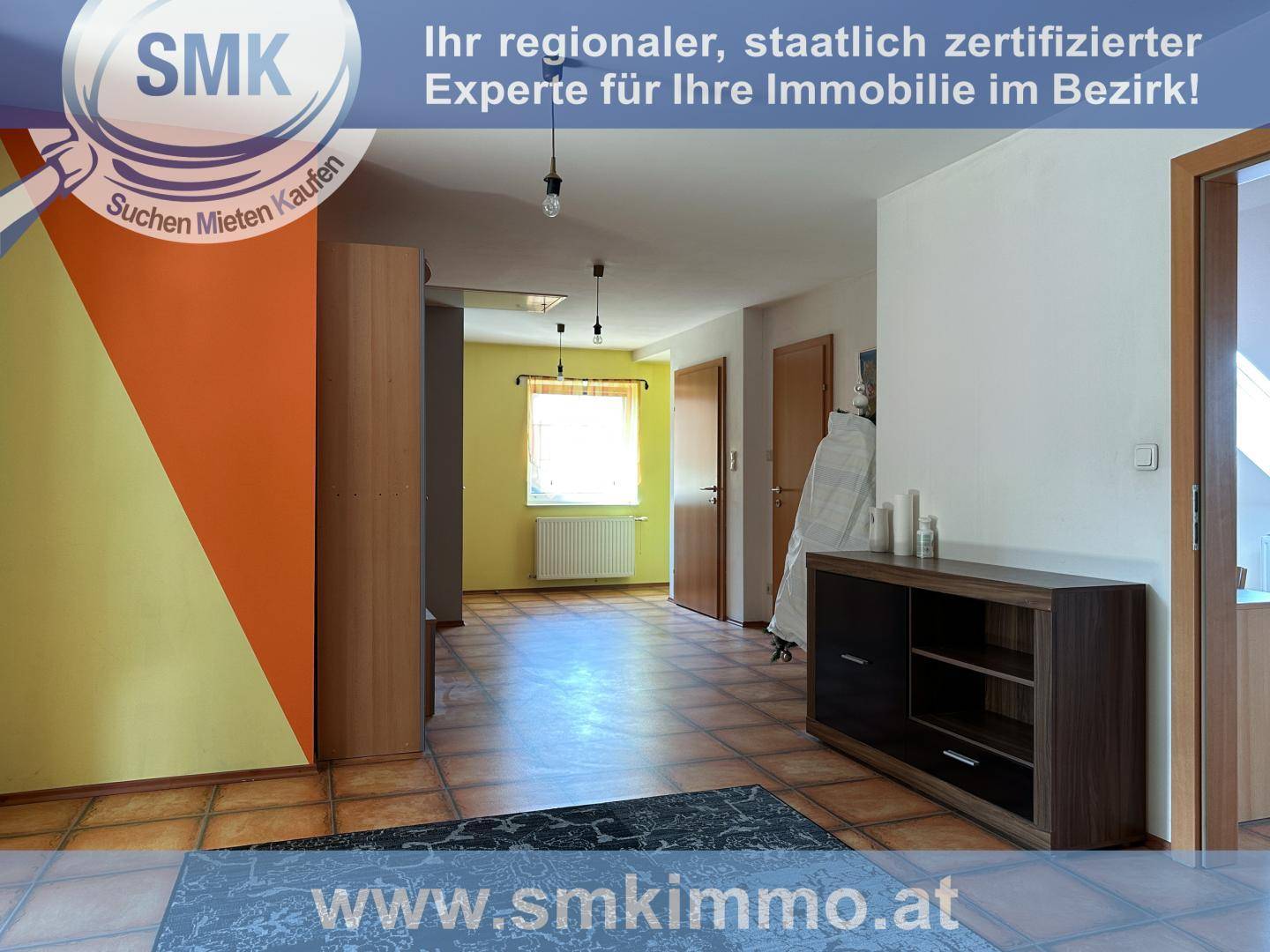 Farbenfroher Flurbereich mit Terrakotta-Fliesenboden und modernem Sideboard.