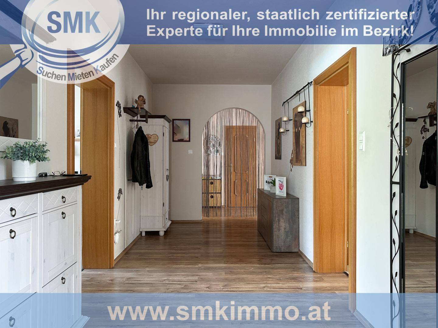 Heller Eingangsbereich mit Holzfußboden, Garderobe und Durchgang zu weiteren Räumen.