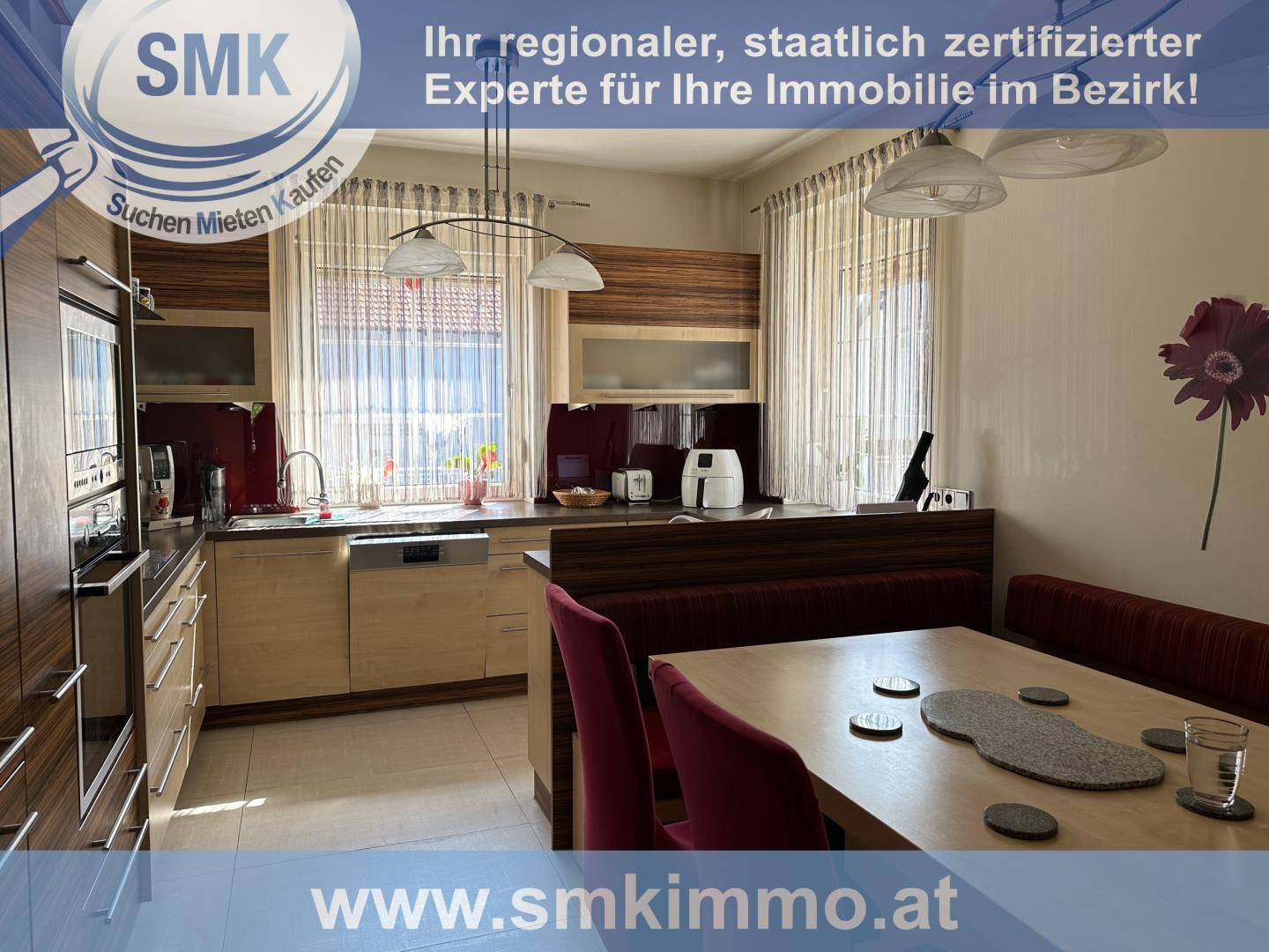 Moderne Einbauküche mit Holzelementen, Essbereich und Blick in den Garten.
